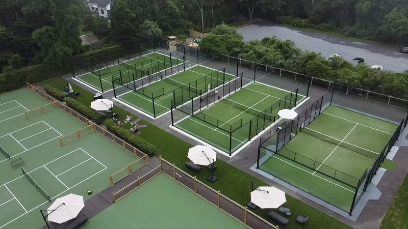 A row of padel courts beside tennis courts, seen from above